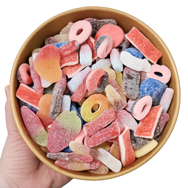 Hand holding a bowl of colorful gummy candies on a white background