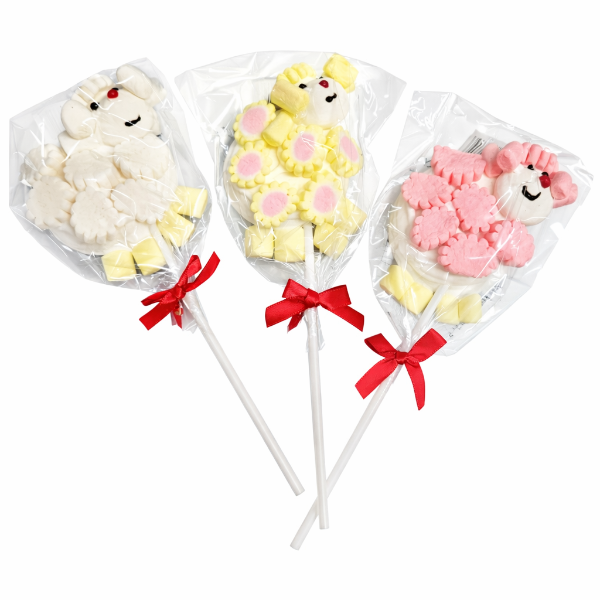 Three lollipops shaped like sheep with colorful candies on sticks, each in a clear bag with a red bow.