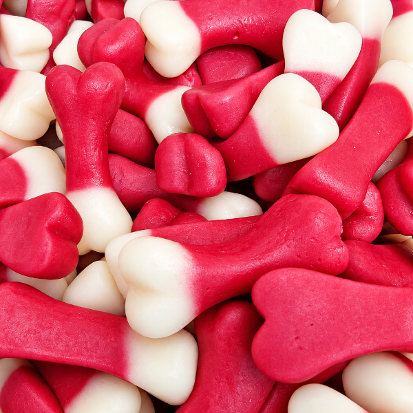 A close-up pile of red and white bone-shaped candies or gummy treats filling the frame.
