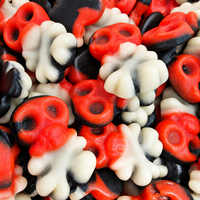 A close-up pile of Halloween-themed skull-shaped candies in red, black, and white.